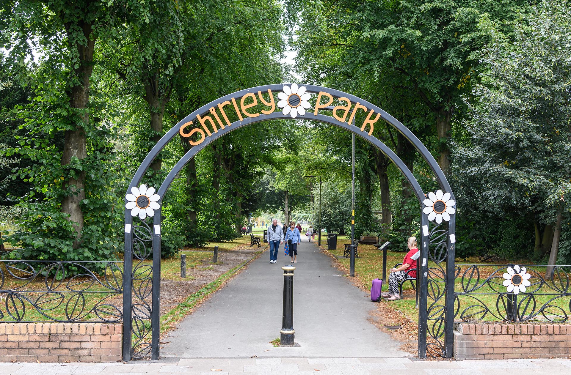 Entrance archway to Shirley Park decorated with flowers.